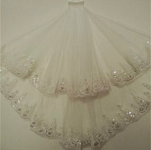Load image into Gallery viewer, New / unused; White 90cm length 2 Tier Sequins Flower Edge Short Bridal Wedding Veil with Comb.
Rovistella Brides. Bridalwear collection: Wedding Veil / accessory new without tags, a brand-new, unused and unworn item.
2 layers, white short veil with comb made of soft tulle, lace and sequin. Unique lace pattern with shiny sequin, comb easy to attach.
Veil length: elbow. Layer 1 ( 90 cm / 35.4 inch ) + Layer 2 ( 60 cm / 23.6 inch ). Width 100 cm approx.
