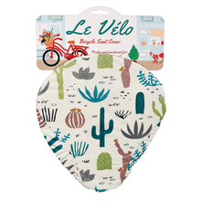 Load image into Gallery viewer, Say goodbye to plastic bags on bike seats in the rain! An original funny design with hand drawn succulent and cactus illustrations, this elasticated Desert in Bloom waterproof saddle cover is both pretty and functional. Size of cover: 23cm (width) x 24.5cm (length) One size fits all. Material: Card, Plastic, Elastic Dimensions: Length: 35 cm Height: 0.5 cm Width: 26.5 cm. Cyclists riders lovers gift idea.