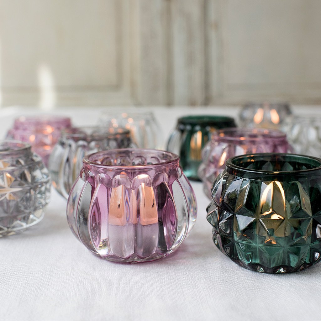 '4 pcs /set of four assorted stylish art deco tea light holders perfect for mantelpieces and as table decorations. Beautify your bathroom with this set during a relaxing bath and create a romantic or relaxing atmosphere with a touch of modernity!      Colours: Clear, Grey, Green, Pink     Material: Heavy Glass     The item comes in a gift box     Scented candles included     Warning: Never leave a candle burning unattended or near flammable objects!
