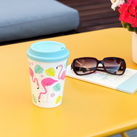 'Reusable plastic mug in original Pink Flamingo Bay print - Drink your favourite drinks with this lovely travel mug. Make your coffee time stylish drinking from this colorful, cool and handy mug. Lovely gift idea, perfect present for flaming lovers'.  Details  - Holds approx. 350ml  - Dishwasher safe (top rack only)  - Not for microwave  - BPA free plastic  Dimensions: Length 9.5cm Height 13.5 cm Width 9.5cm