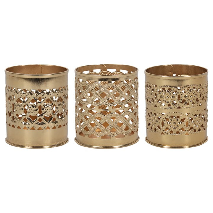 'Set of 3 KASBAH DECORATIVE GOLDEN TEALIGHT HOLDER' - This trio of iron tealight holders feature a variety of ornate cutout details and embossed patterns. Place a tealight candle inside to instantly pull a room together and create an elegant atmosphere. Sold in multiples of 3, one of each style.      Material: Iron     Dimensions: H 7cm x W 6cm x D 6cm     Scented tealight candles included     Gift idea / home decor / romantic encounter / religious item /oriental style/ wedding decorations