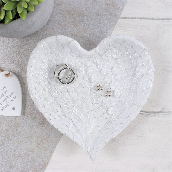  GLITTER HEART SHAPED ANGEL WING TRINKET DISH This beautiful angel wing inspired jewellery white dish is presented in the shape of a heart. The dish is finished with clear glitter flakes to give a beautiful sparkly effect when the light catches it. Home decor item and Christmas gift idea :)      Material: Resin     Dimensions: Height:16cm Width:16cm Diameter: 3cm