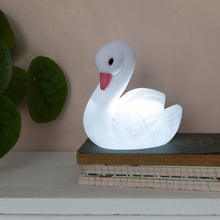 Load image into Gallery viewer, Relax in company of this adorable Little Swan night light, a perfect accessory for peaceful sleep in a sweet dream night. Put it on the bedside table or in a place where you need a soft light. Beloved article both children and adults as this swan has a nice and elegant style at the same time.      Requires 3 x LR44 batteries (included)     WARNING! Choking hazard; not for children under 3 years old     Material: Plastic     Dimensions: Length 11 cm Height 12.5 cm Width 7.5 cm
