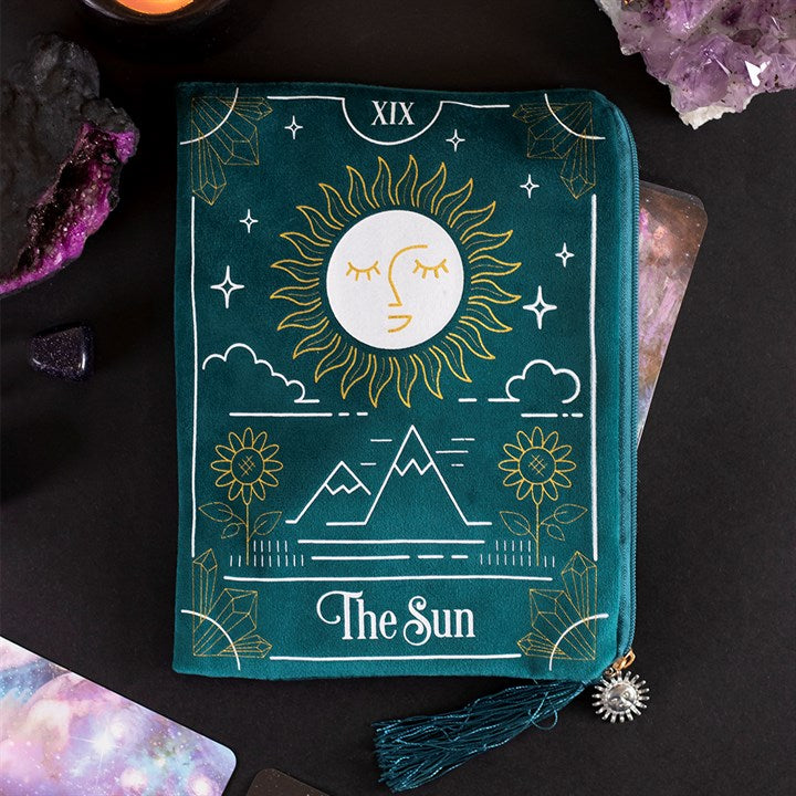 THE SUN TAROT CARD ZIPPERED BAG This velvet zipper pouch is the perfect place to keep tarot decks, crystals, beauty products and other treasures. Features a stunning white and gold sun tarot card illustration on the front and a matching tassel and gold sun charm on the zipper. Designed by Something Different and part of The Fortune Teller range of mystical gifts and home decor. Fabric and Polyester  Height 15cm x Width 20cm x Diameter 0.75cm